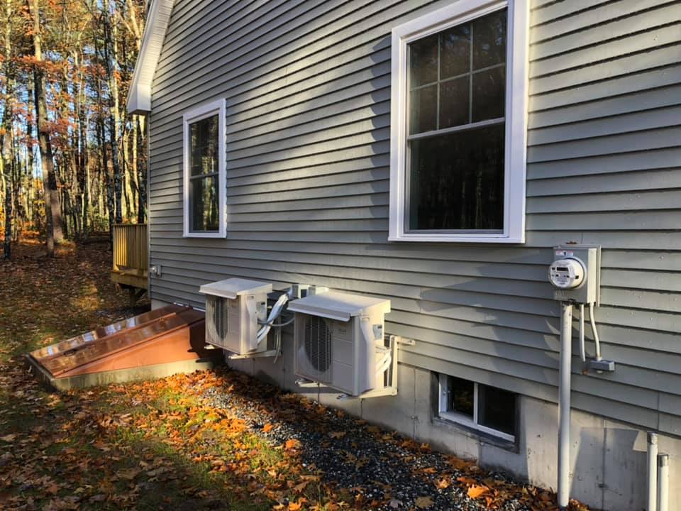 Another sleek, modern looking heat pump outside a house